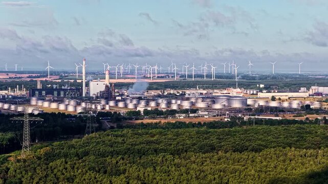 Aerial view of PCK Raffinerie GmbH refinery with numerous storage tanks and wind turbines in the background in SchwedtOder, Brandenburg, Germany.