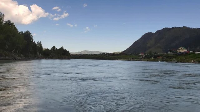 A motorboat ride along mountain river. Slow motion of speedboating on Altai river Katun in rainy day