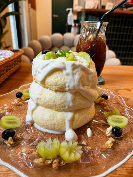 Fluffy Japanese souffl&eacute; pancakes topped with whipped cream and fresh green grapes