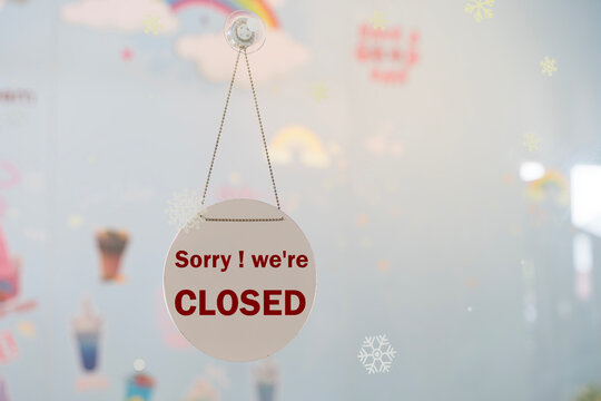 Sorry We&rsquo;re Closed Sign Hanging on Glass Door of Shop or Cafe