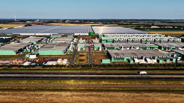 Aerial view of the Microsoft Hyperscale Data Center Campus at Agriport A7, with industrial buildings and greenhouses near the highway in Middenmeer, Noord-Holland, Netherlands.