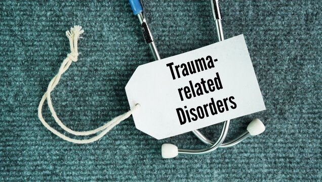 Stethoscope and paper tag with the words trauma-related disorders. mental health conditions that develop after a person experiences or witnesses a deeply stressful or life-threatening event.