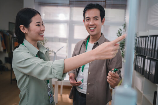 esg concept, Office coworkers discussing workplace task with friendly expressions and pointing toward shared direction