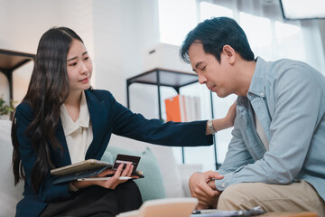 Fototapeta premium Asian financial advisor offering wealth planning support to concerned client during compassionate consultation in modern office setting with professional guidance and empathy