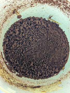 Top view of instant coffee granules inside a plastic container.