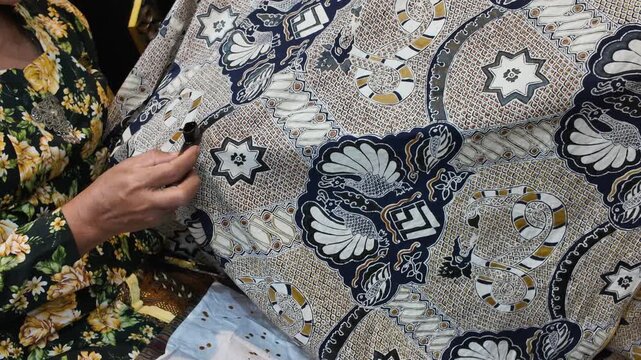 Detailed Close-Up of Artisan Creating Batik Pattern on Fabric