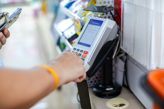 Selective focus to Customer Entering PIN Code on POS Terminal Machine in Store