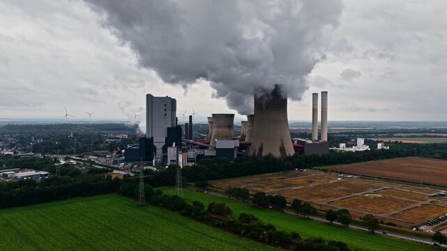 Aerial view of RWE Power AG power plant Niederaussem with cooling towers and smoke emissions in Bergheim, Nordrhein-Westfalen, Germany.