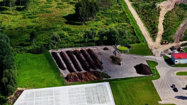 Aerial view of composting facility with rows of organic material and circular tank in Kedainiai, Kaunas County, Lithuania.