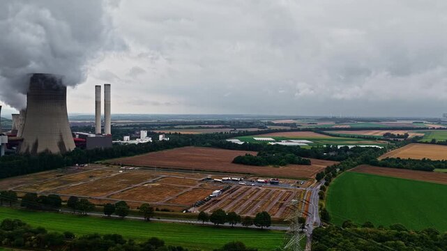 Aerial view of the RWE Power AG power plant Niederaussem with cooling towers emitting steam, surrounded by agricultural fields and rural landscape in Bergheim, Nordrhein-Westfalen, Germany.