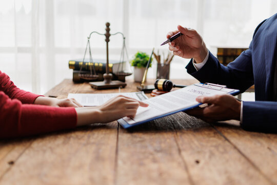 Lawyer advising client on a contract, pointing to legal document details during a consultation, discussing important terms and conditions for a new agreement