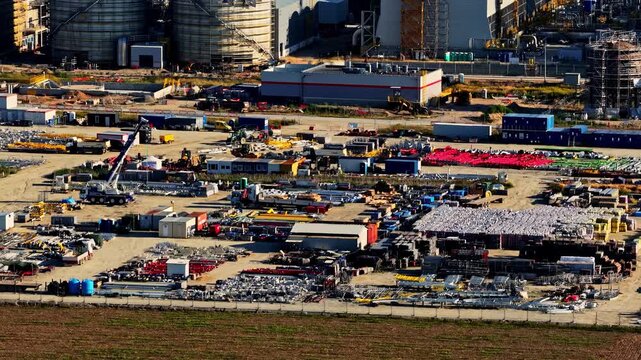 Aerial view of the Orlen Plock Production Plant featuring industrial storage areas, construction equipment, and refinery infrastructure in Plock, Mazowieckie, Poland.
