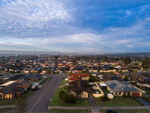 Dawn scene overlooking houses and rooftops of homes along street in Australian suburb