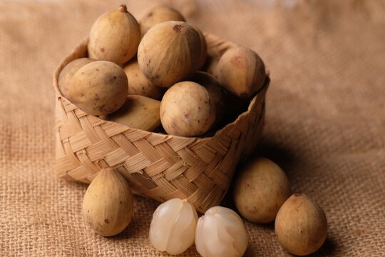 Duku fruit in a woven bamboo container. Tropical fruit. Lansium domesticum. 