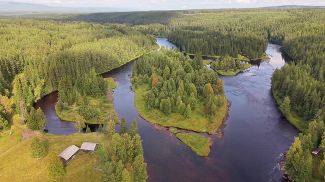 Aerial view of the meandering Vasterdal River flowing through dense coniferous forests and green landscapes in Salen, Dalarna County, Sweden.