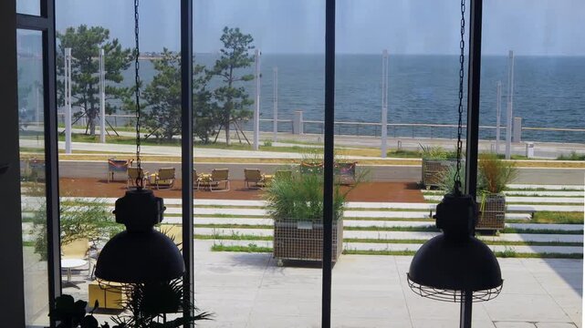 The sea is visible beyond the cafe's glass window.카페의 유리창 너머로 바다가보입니다.