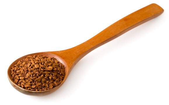 Freeze dried coffee powder in a wooden spoon, isolated on a white background.