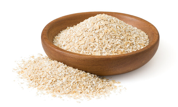 Uncooked oat bran in the wooden plate, isolated on white background.