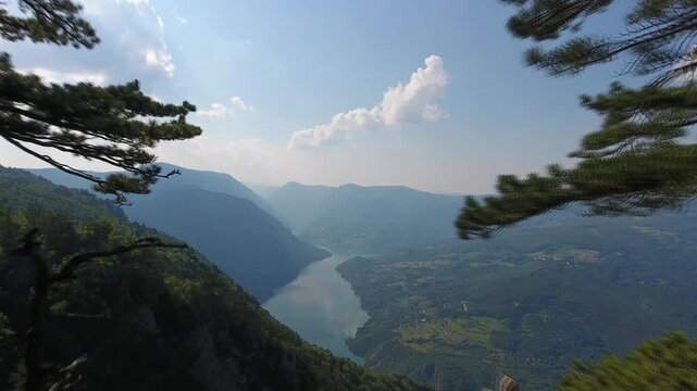 Aerial view of the Banjska Stena viewpoint overlooking the Drina River canyon with pine trees and wooden fencing in Rastiste, Zlatiborski okrug, Serbia.