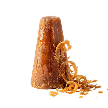 Palm sugar loaf with shaved curls rests against a solid transparent background jaggery gula