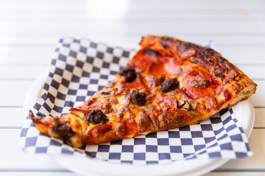 a generous slice of pizza on a paper plate
