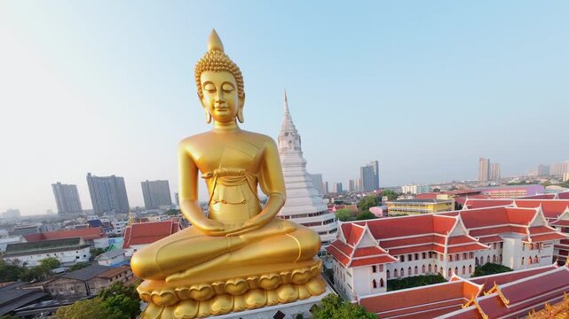 Cinematic FPV drone fly around giant golden Buddha at Wat Paknam temple in Bangkok, Thailand. Aerial movement over city skyline and Buddhist landmark.