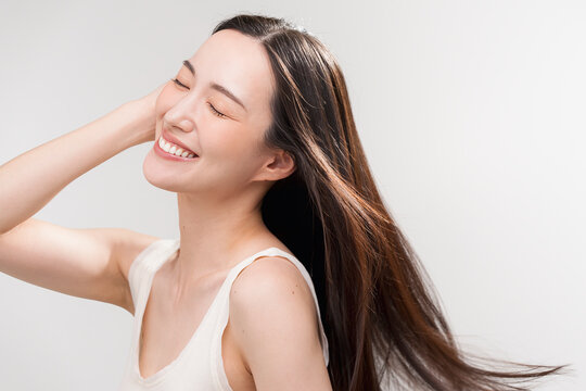 笑顔の日本人女性の長く美しい髪が風になびいている　