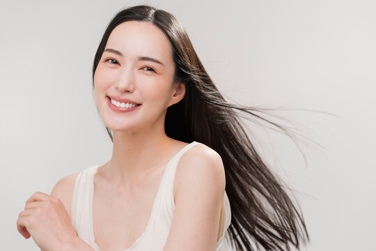笑顔の日本人女性の長く美しい髪が風になびいている　