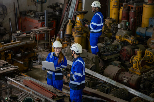 Team of industrial worker is checking the setup value of  metal casting machine by automated monitor while working inside factory for safety industry usage