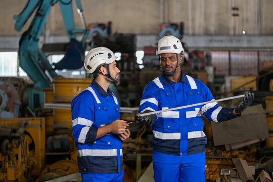 Team of industrial worker is checking the setup value of  metal casting machine by automated monitor while working inside factory for safety industry usage