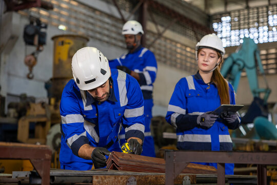 Team of industrial worker is measuring and checking the setup value of  machine while working inside automate factory for safety industry