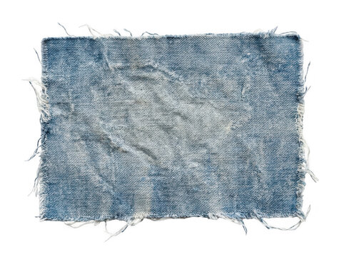 Distressed blue denim fabric reveals frayed edges and worn texture against a plain backdrop.