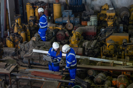 Team of industrial worker is checking the setup value of  metal casting machine by automated monitor while working inside factory for safety industry usage
