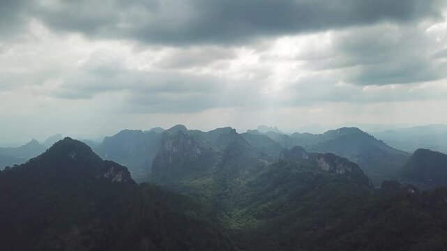 Aerial view of limestone karst mountains in Phang Nga under a dramatic cloudy sky in Phang Nga, Thailand.
