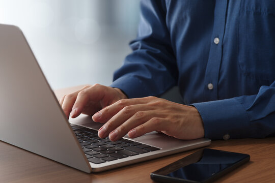 Remote work concept with professional using laptop at home office. Closeup of hands and keyboard. Business technologies.