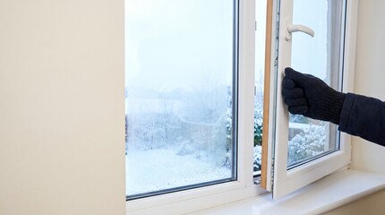 Fototapeta premium 冬の結露対策で住宅の窓を開けて換気する手元