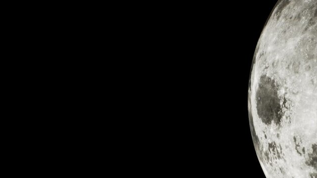 The moon is bright and detailed, showing craters and surface features. It is a clear night with a dark sky surrounding the moon. The view is from an unknown location on earth.