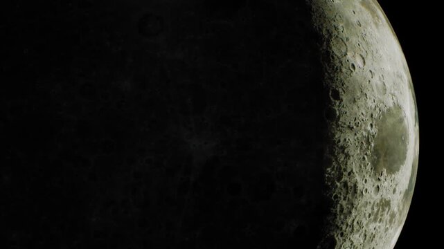 The moon shines bright in the night sky. Craters and surface details are clear. The view captures a portion of the lunar surface. It is a still night with no clouds present.