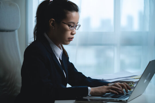 Businesswoman Working Alone on Laptop in Modern Office, Showing Concentration and Professional Productivity During a Busy Workday