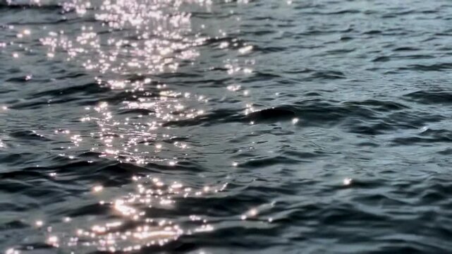 Sunlight creates bright reflections across rippling water on Lake Bunyonyi in Kabale District, Uganda, with textured waves filling the frame, fast motion.