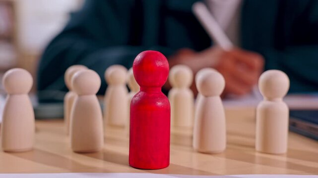 Red wooden pawn among beige chessboard pieces, business leadership competition strategy decision planning with thoughtful professional background, strategic board game closeup and corporate success