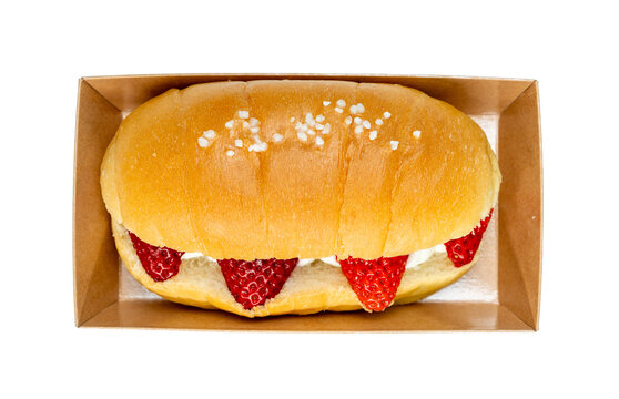 Brown salted bread or Shio pan with fresh strawberries in paper box on transparent, Clipping path, Top view.