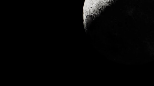 A part of the moon is seen in the night sky. The moons surface shows craters and shadows. There are no clouds in the sky around it. The scene captures the beauty of the moon.