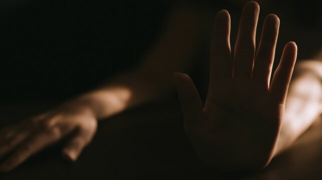 Hand reaching out in a dimly lit room during an evening setting