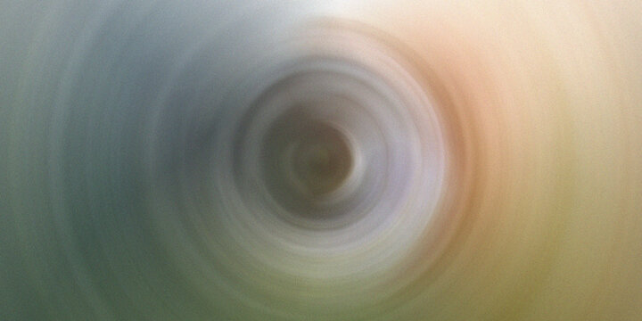 Abstract blurry vortex with subtle gradient colors from grey to orange, creating a soft, mesmerizing background.