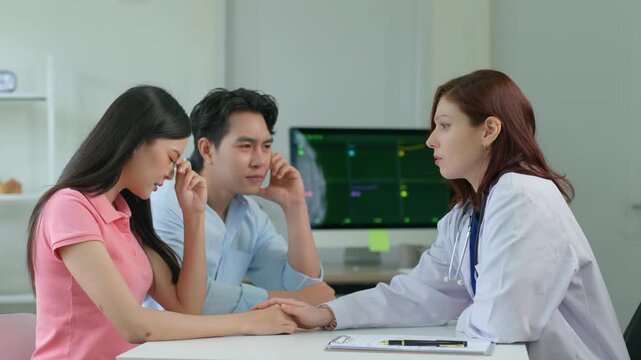 Doctor comforting crying patient and worried husband after bad news diagnosis in a hospital clinic consultation