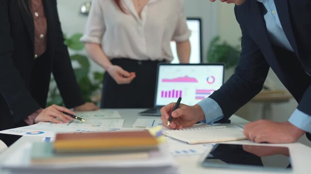 Professional business team analyzing financial data charts and graphs during a corporate meeting in a modern office boardroom