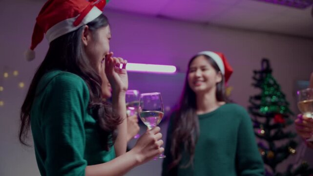 Group of asian friends dancing and celebrating at a Christmas or New Year's Eve party at home