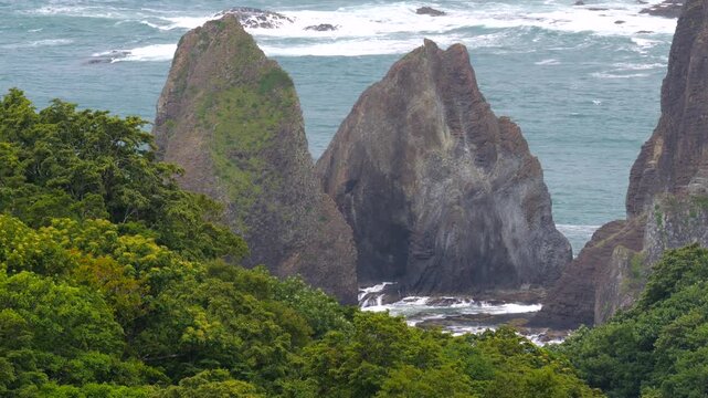 尖った岩島と打ち寄せる波が見える海の風景。