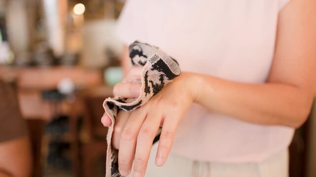 Close Up of Person Cleaning Hands with Patterned Towel in Restaurant